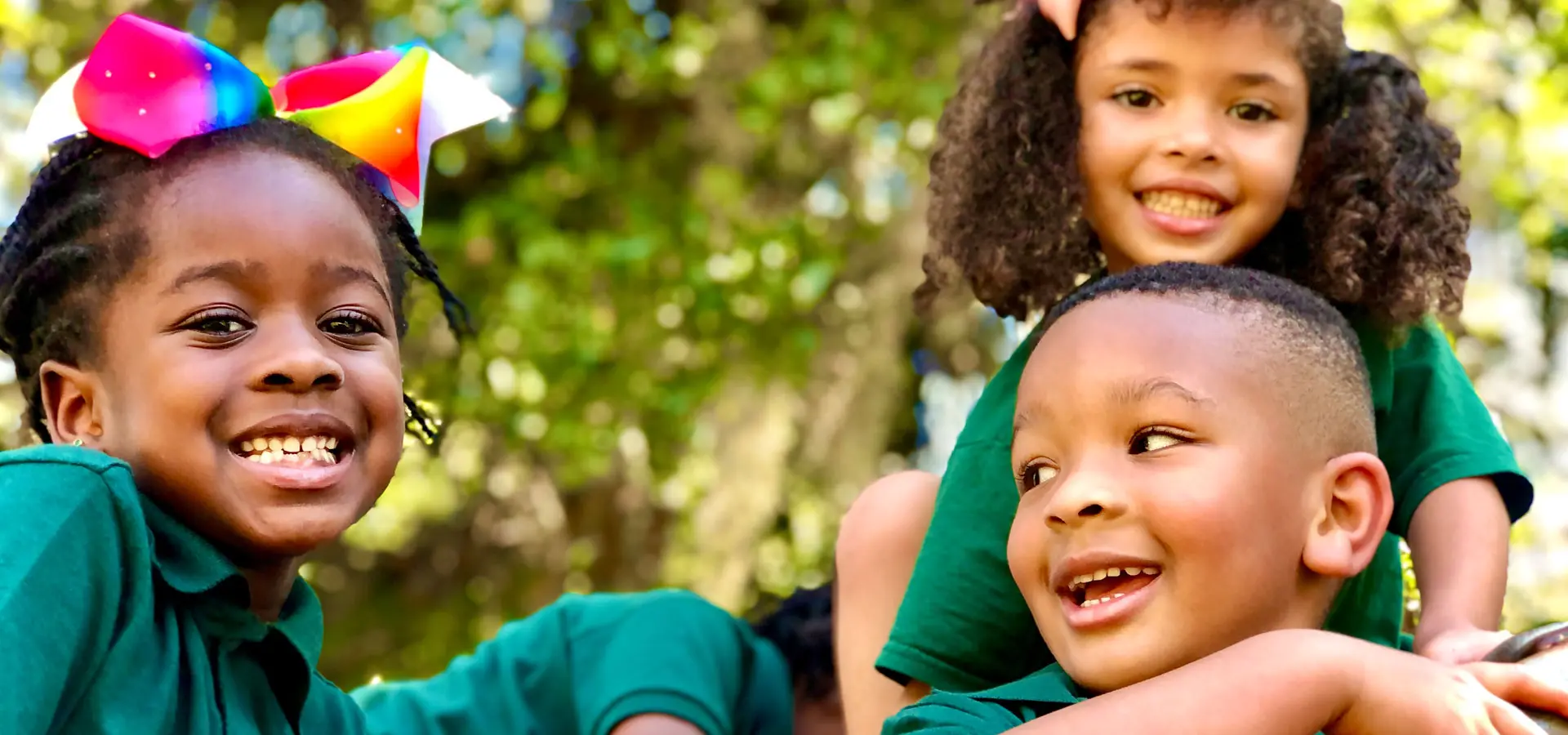 Two children are smiling and holding a kite.